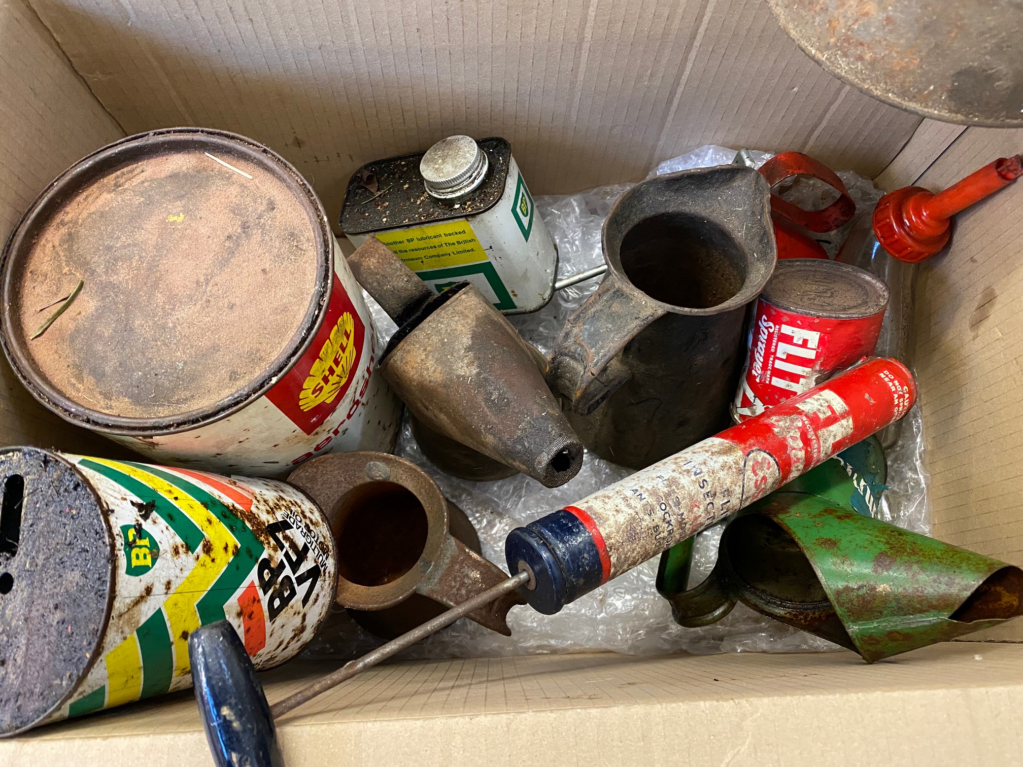A box of assorted oil cans and measures, including an Esso Flit gun, BP, Shell etc.