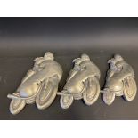 A graduated set of three wall hanging plaques of motorcycles and their riders, the largest 7 1/2"