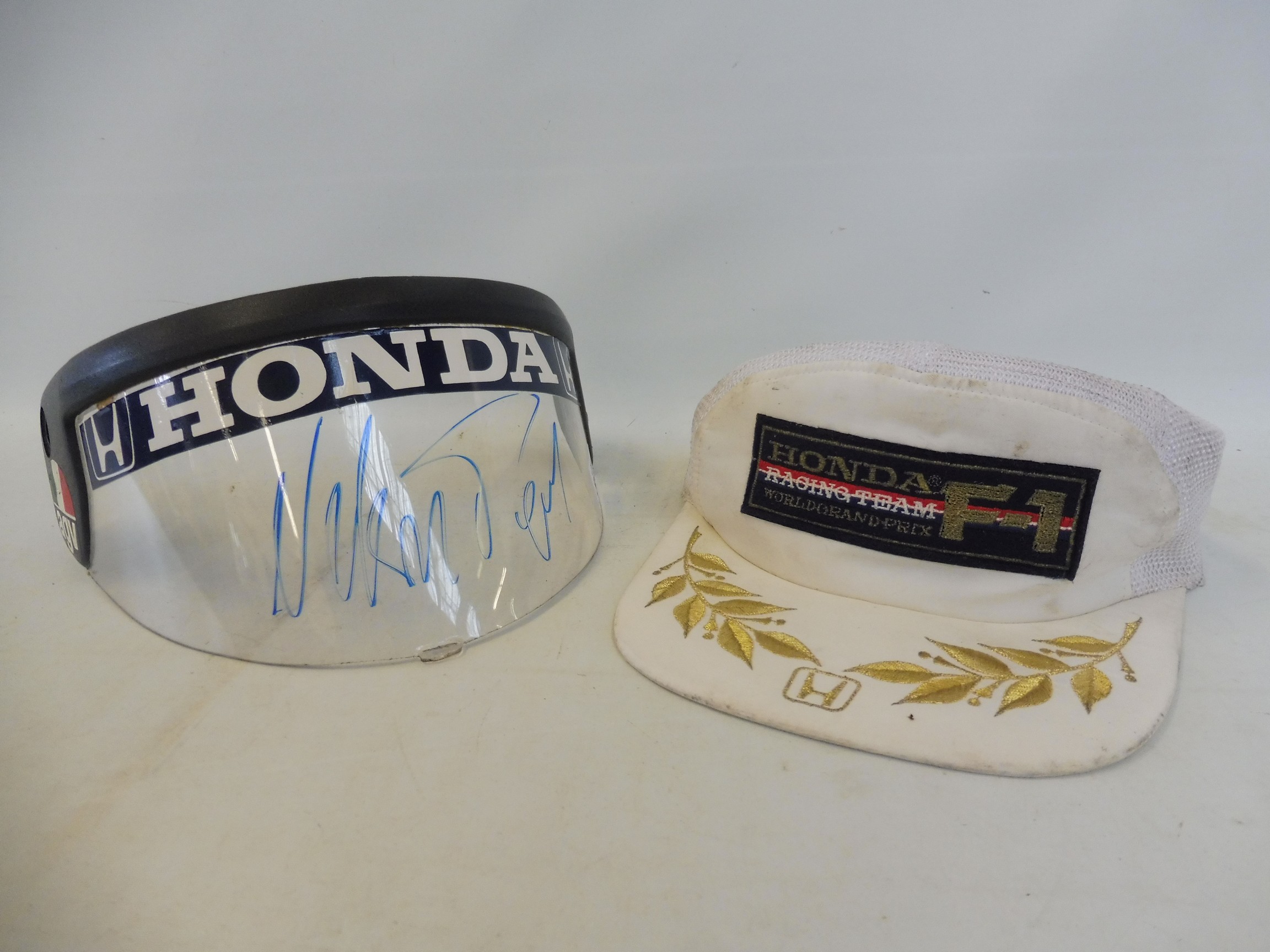 A Honda Formula One team visor, signed in pen by Nelson Piquet and a Honda F1 Racing Team cap,