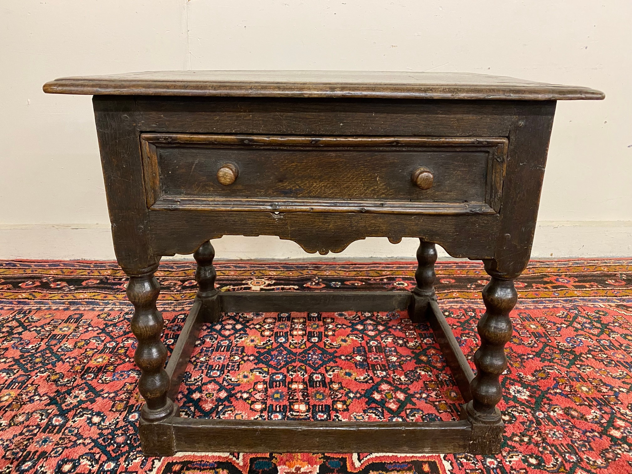 A primitive 17th Century Welsh oak side table with bobbin supports, 30 1/2" w x 26" h x 23" d.