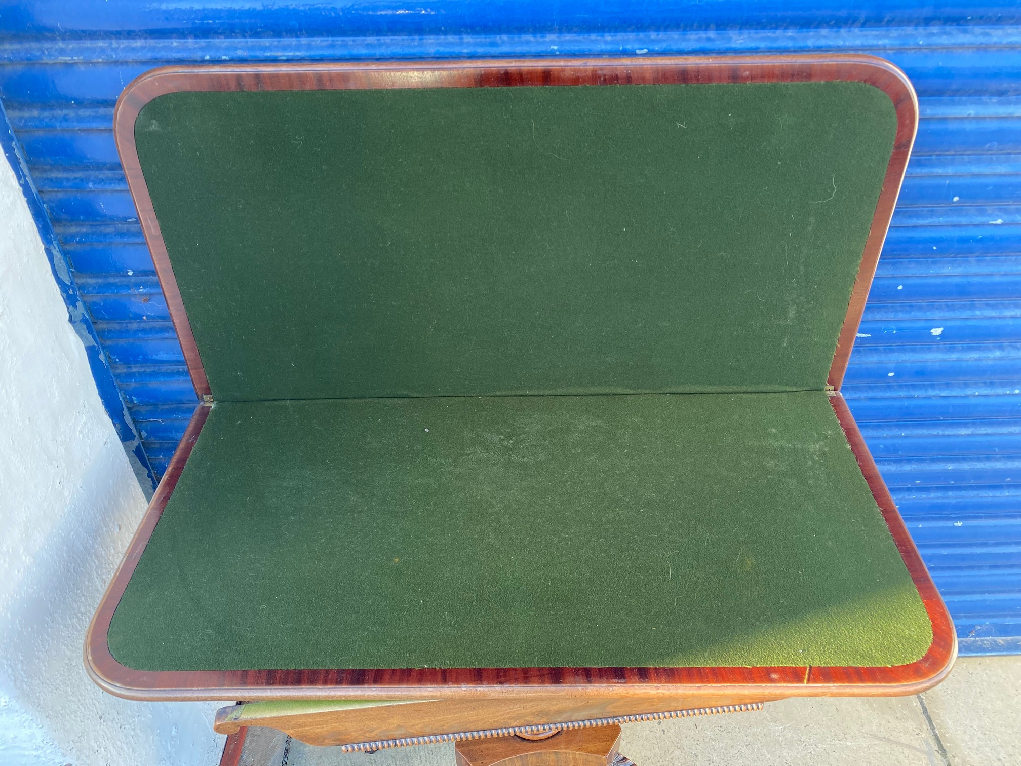 An early 19th Century mahogany fold over card table, raised upon a turned stem to splayed supports. - Image 4 of 6