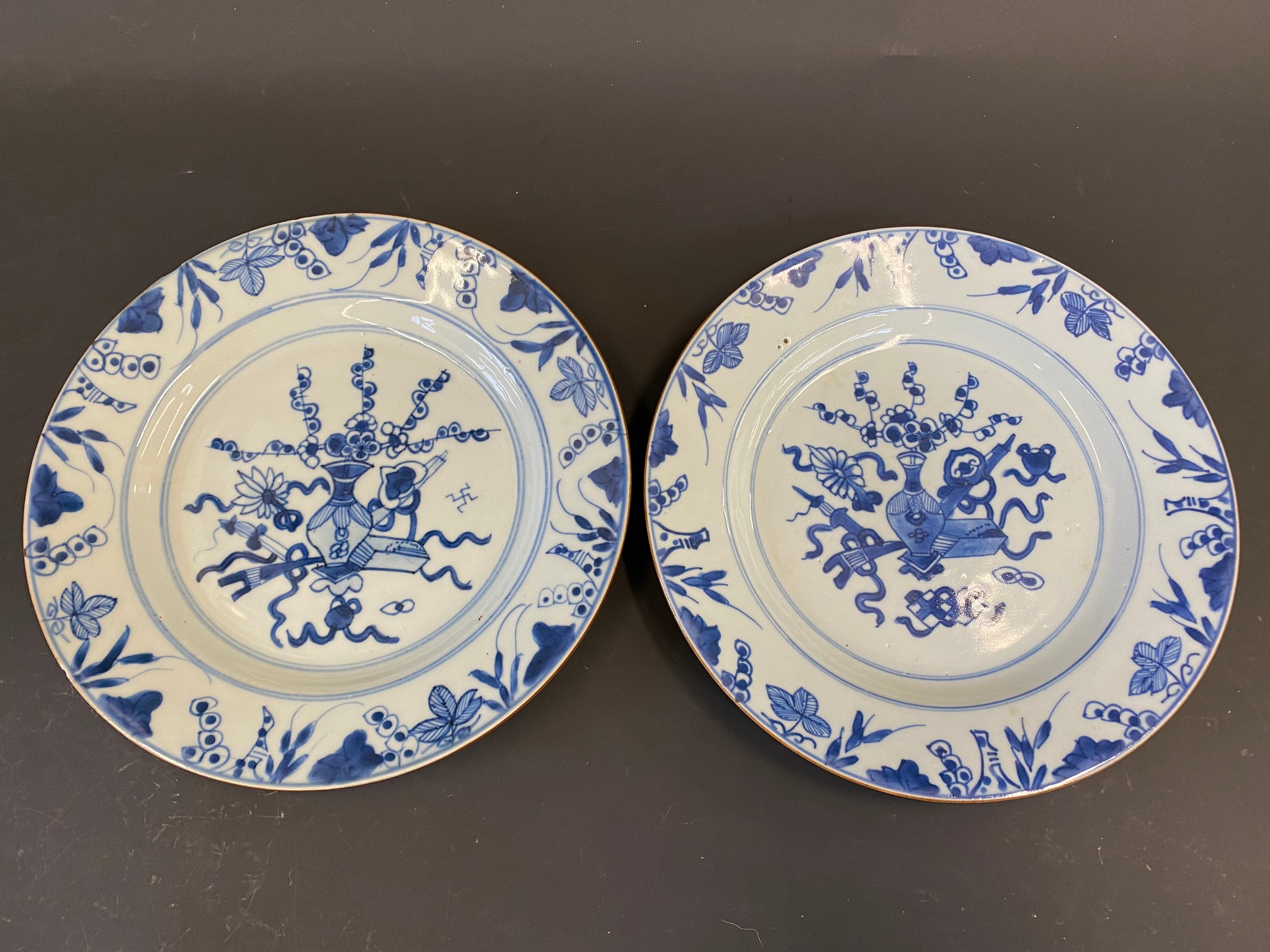 A pair of Chinese blue and white plates decorated with a vase of flowers to the centre, 19th Century