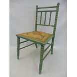 A green painted child's chair with bobbin turnings.