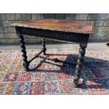 A Victorian carved oak single drawer side table raised upon barley twist supports joined by a