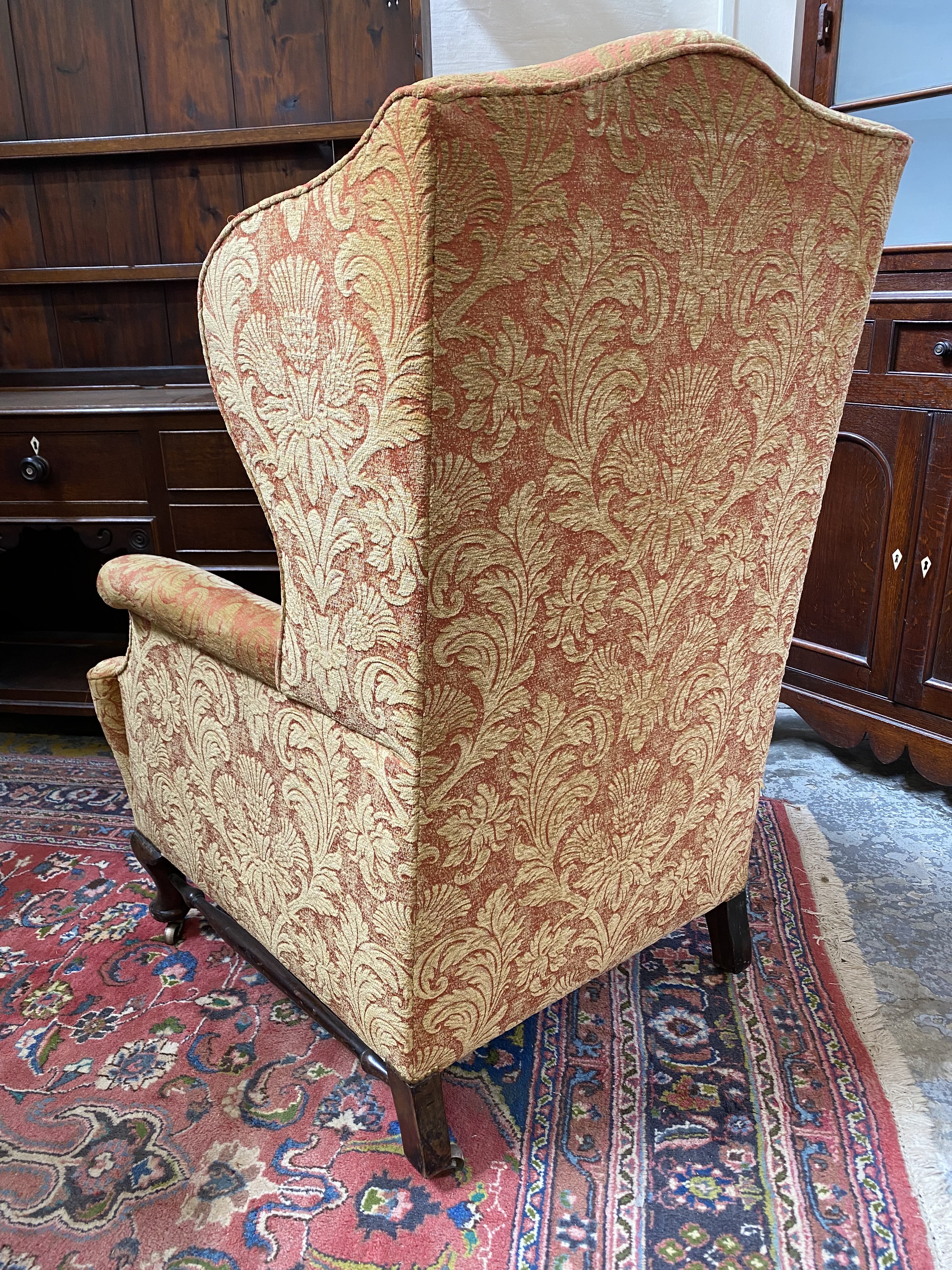 An upholstered wing back armchair raised upon mahogany supports, joined by a stretcher, probably - Image 6 of 7