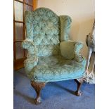 An 18th Century style button back upholstered wing back armchair, raised upon carved cabriole walnut