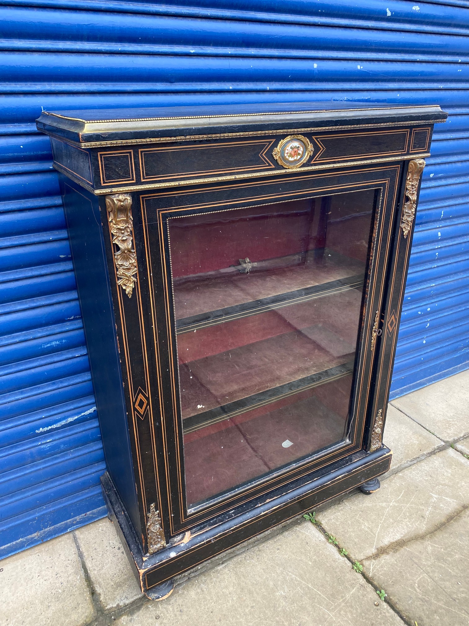 A 19th Century ebonised and brass mounted pier cabinet, with retailer's label to the back for