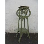 An Art Nouveau style jardinere stand with a worn paint finish.