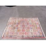 A large early 20th Century rug of repeating square design, 110" (excluding fringe) x 80".