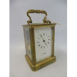 A brass carriage clock with secondary dial and repeater, keys attached.