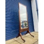 A mahogany cheval mirror of plain rectangular form raised upon swept supports ending in bronze front