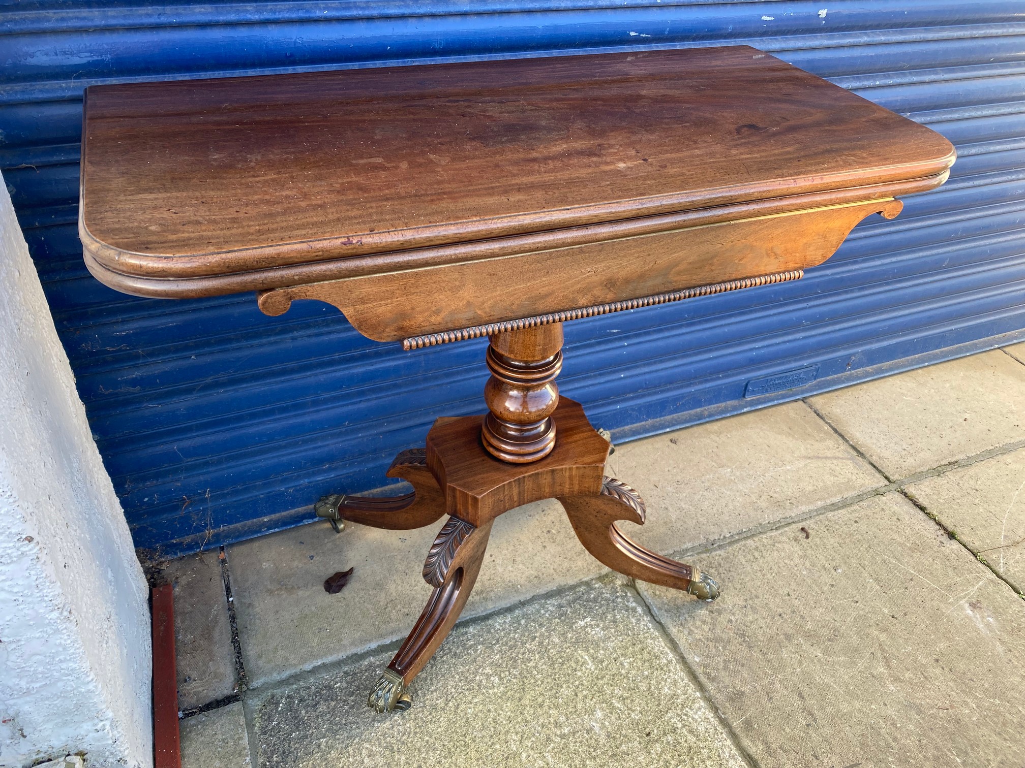 An early 19th Century mahogany fold over card table, raised upon a turned stem to splayed supports. - Image 2 of 6