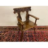 An early 19th Century walnut scabello type chair with ornate carved back.