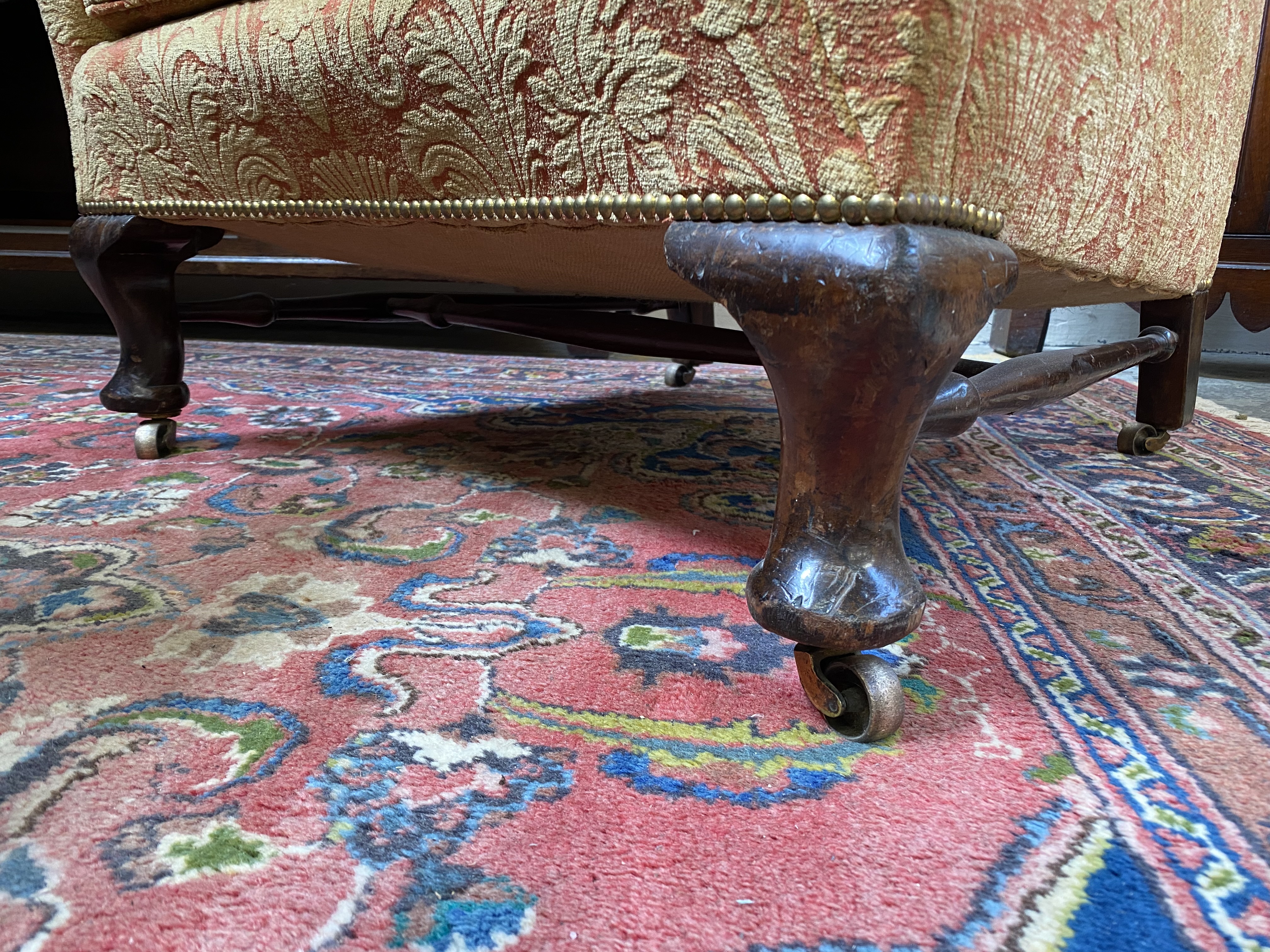 An upholstered wing back armchair raised upon mahogany supports, joined by a stretcher, probably - Image 3 of 7