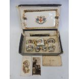 A cased miniature porcelain tea set, each piece having a crest, advertising the City of London,