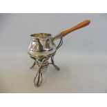 An Art Nouveau style silver miniature brandy saucepan with pouring spout, raised on a spirit