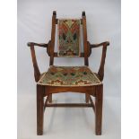 An Arts and Crafts oak framed armchair, the seat and back upholstered in Liberty print Ianthe.