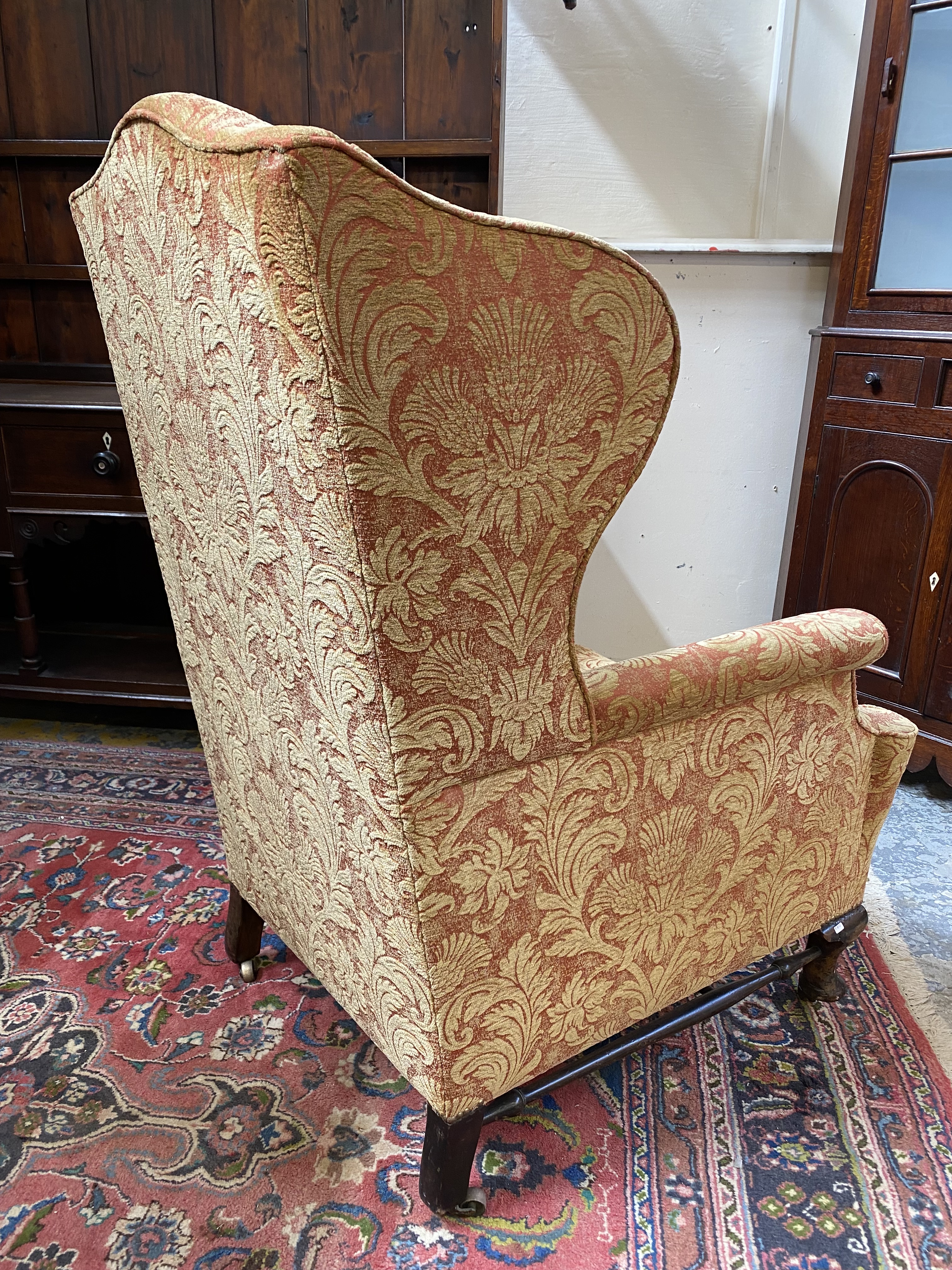 An upholstered wing back armchair raised upon mahogany supports, joined by a stretcher, probably - Image 7 of 7