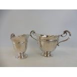 A silver two handled cup, and matching cream jug, London 1902.
