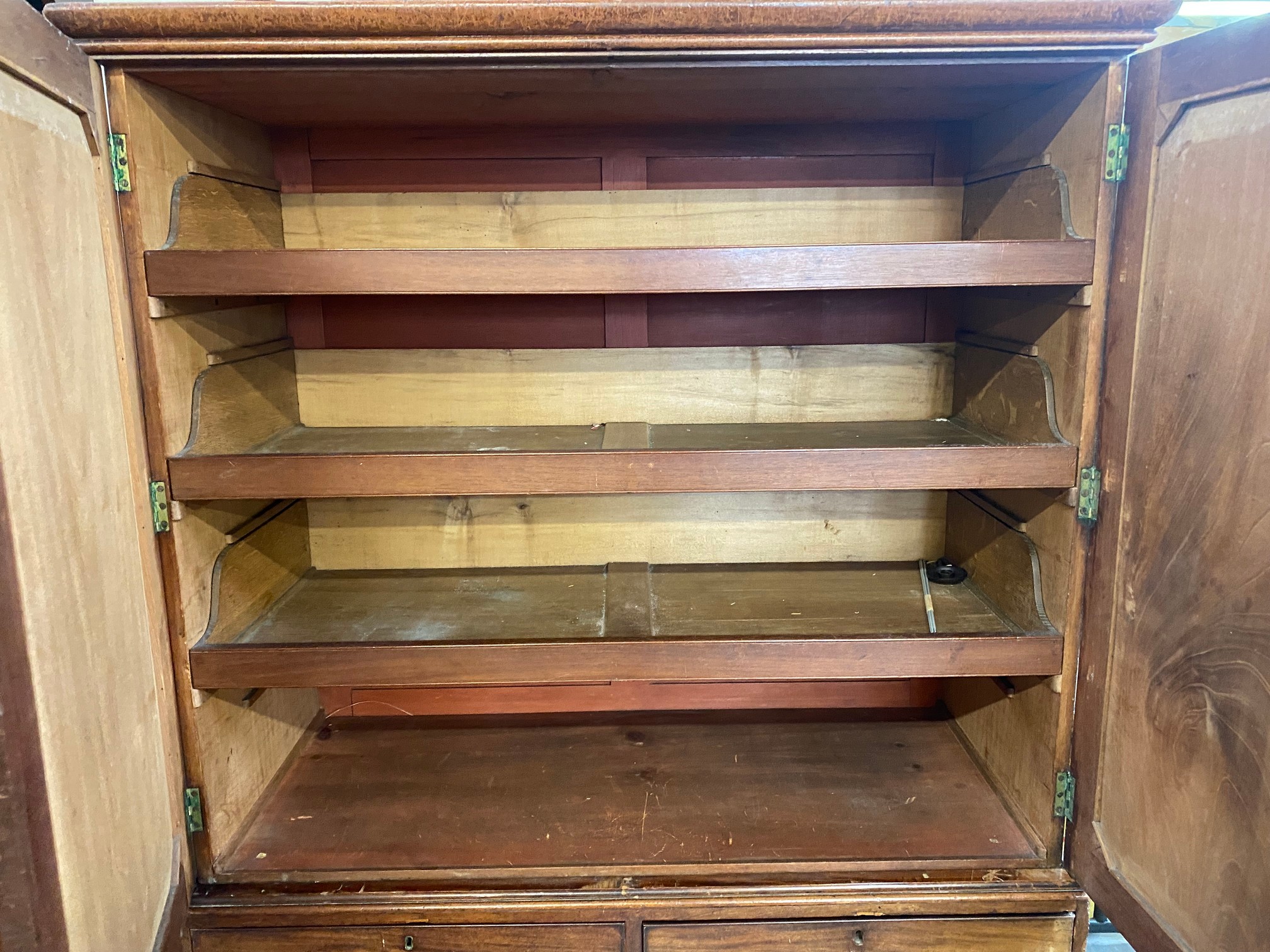 An early 19th Century mahogany linen press of two panelled doors enclosing slides, above a three - Image 5 of 8