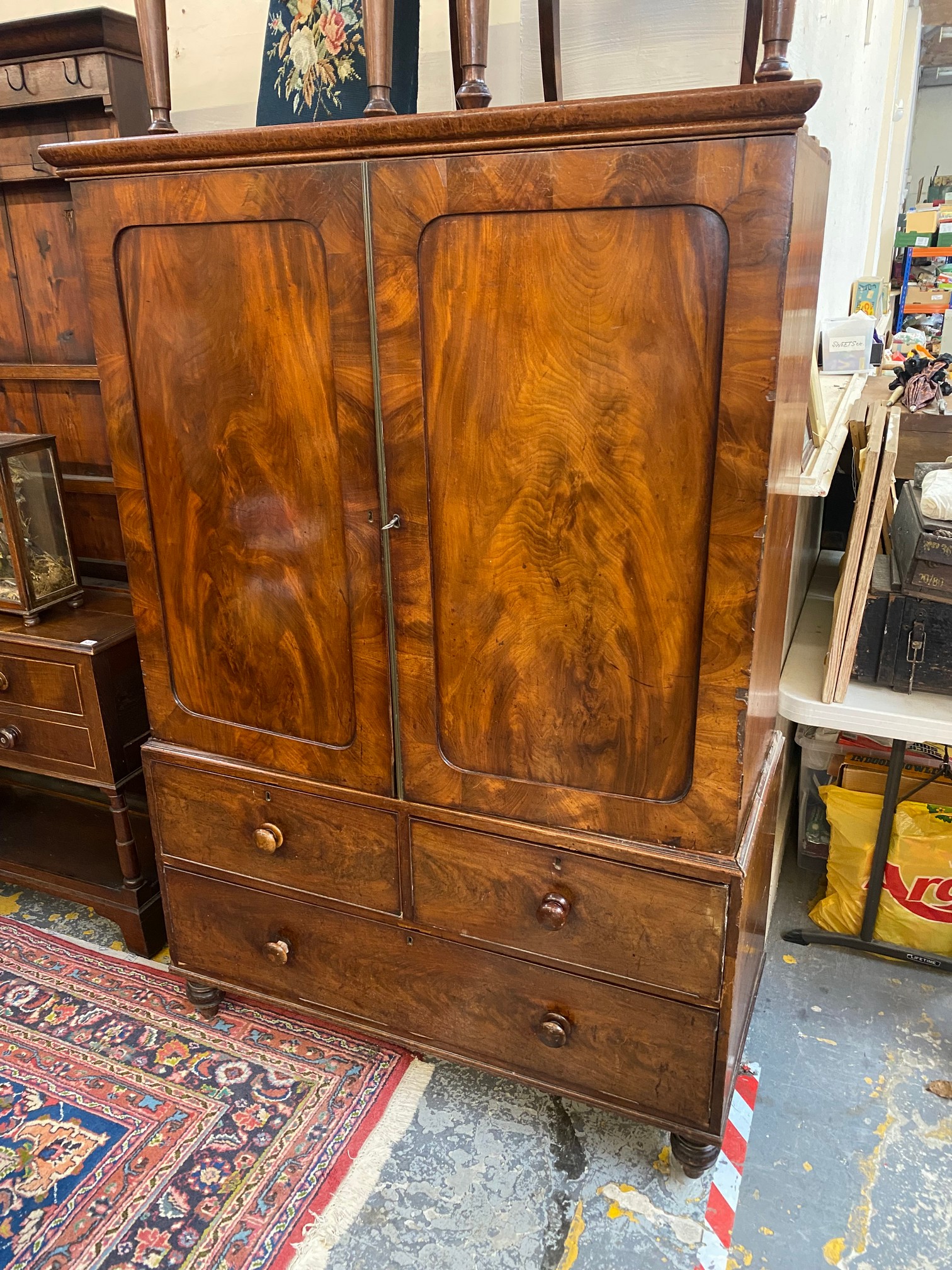 An early 19th Century mahogany linen press of two panelled doors enclosing slides, above a three