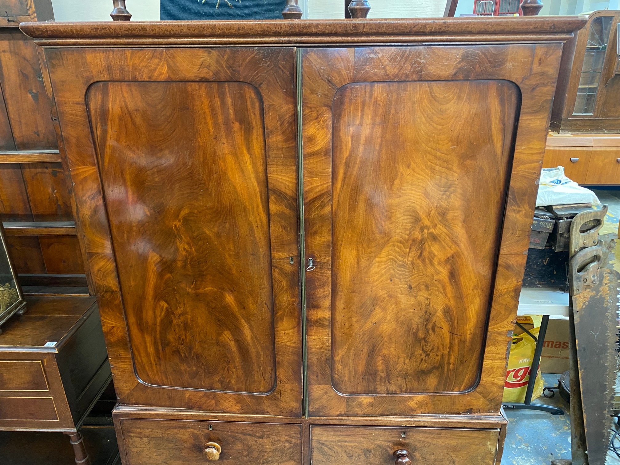 An early 19th Century mahogany linen press of two panelled doors enclosing slides, above a three - Image 2 of 8