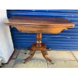 An early 19th Century mahogany fold over card table, raised upon a turned stem to splayed supports.