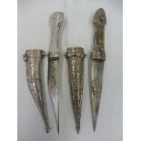 Two white metal cased Eastern daggers.
