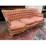 A 19th Century French style button back upholstered settee with pointed show-wood frame and loose