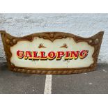 A colourful rounding board from a fairground carousel, with the word 'Carousel' painted to the