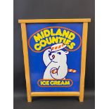 A Midland Counties Ice Cream pictorial tin advertising sign in a wooden frame, 21 x 28".
