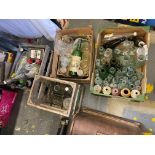 Four crates of assorted glass bottles, beer bottles etc.