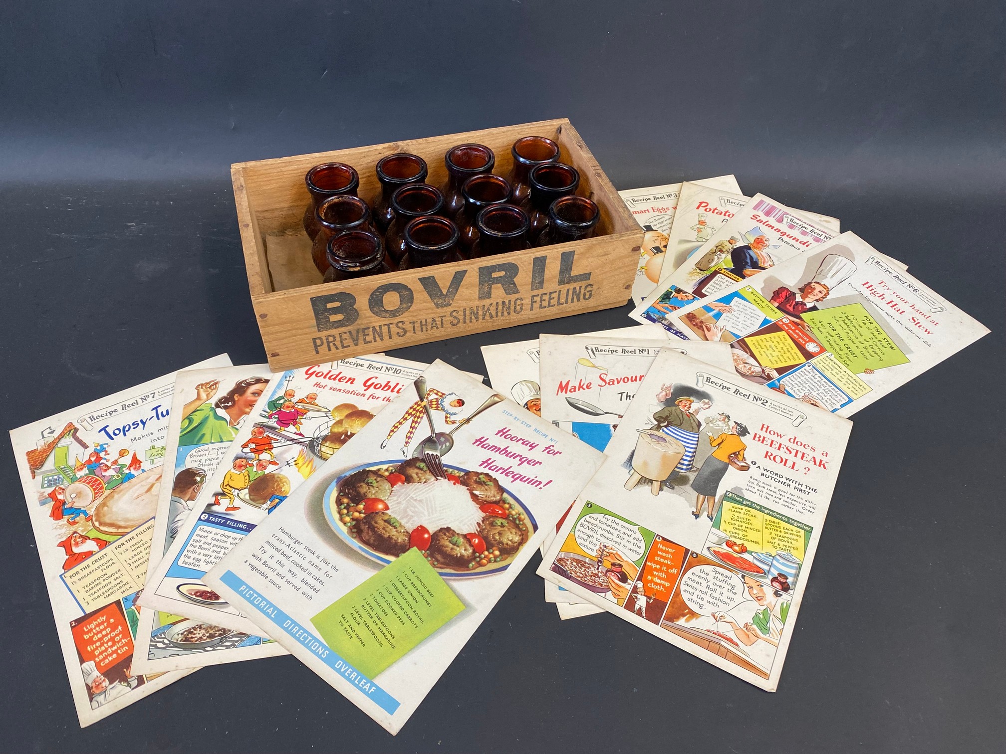 A Bovril wooden counter top box, 12 glass jars and various menu cards.