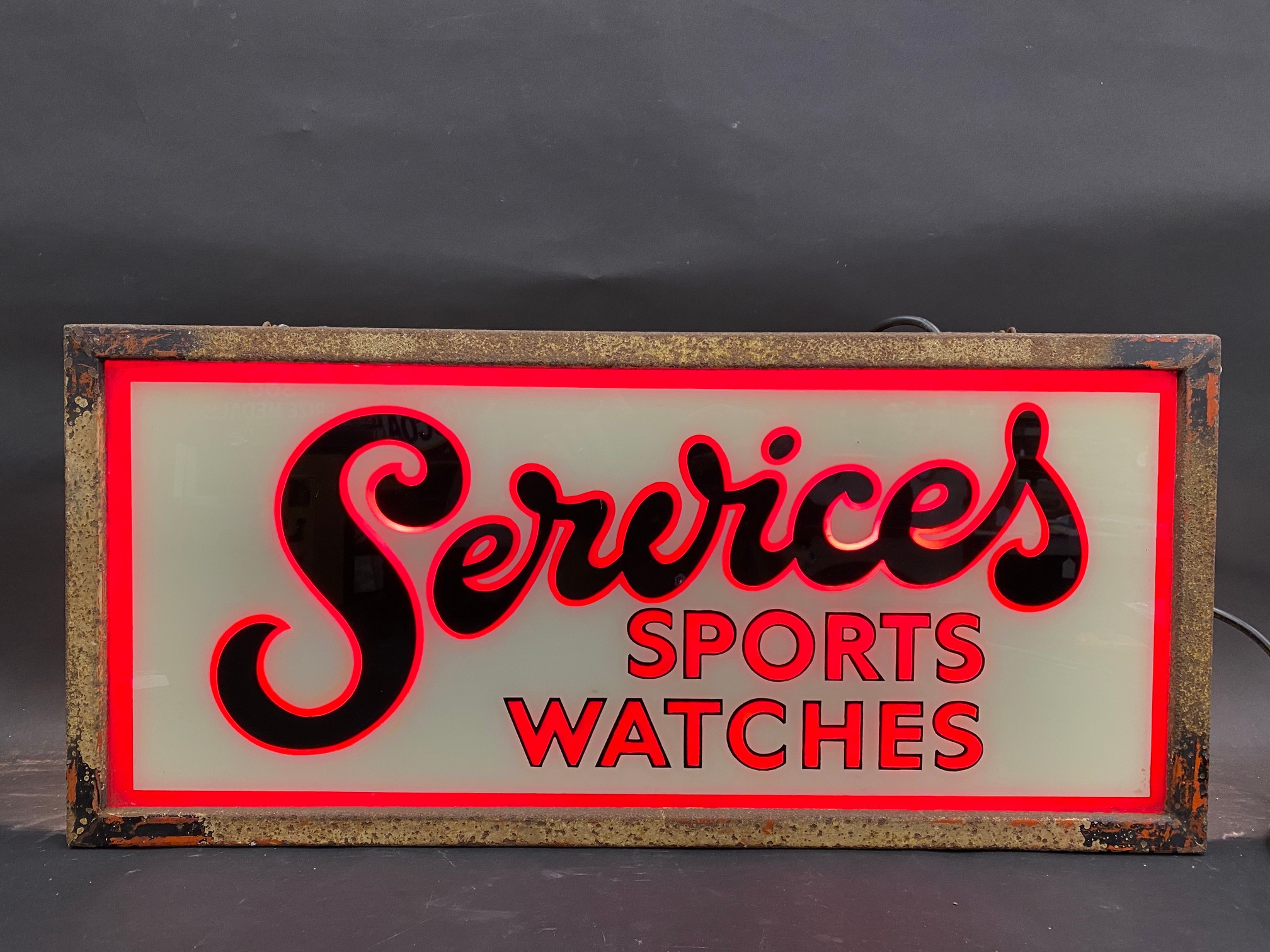 A Services Sports Watches illuminated shop window display sign, 26 3/4" w x 12" h x 8" d.