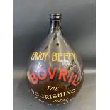 A very large brown glass jar bearing hand painted advertising for Bovril, approx. 25" high.
