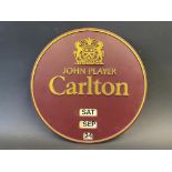 A circular plastic wall mounted calendar advertising John Player 'Carlton', made by Invicta