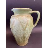 A large green glazed jug in the Art Deco taste, bears an indistinct inscription to the base,
