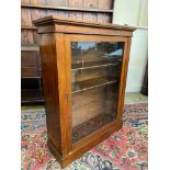A Victorian walnut pier cabinet/bookcase with single glazed door, adjustable shelves and a plinth