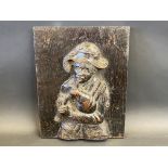 A 19th Century carved oak panel of a bagpiper, 13 x 10".