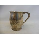 A silver christening mug of bulbous shape with a scrolled handle, bearing engraved name, 3 1/4" h