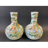 A pair of Chinese bulbous vases mostly in the famille verte palette, decorated with numerous