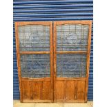 A pair of oak framed and glazed doors in the Art Nouveau taste, each 27 1/2" w x 67 1/2" h.