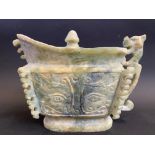 A Chinese carved soapstone vessel of archaic design with an animal design handle, 8" wide.