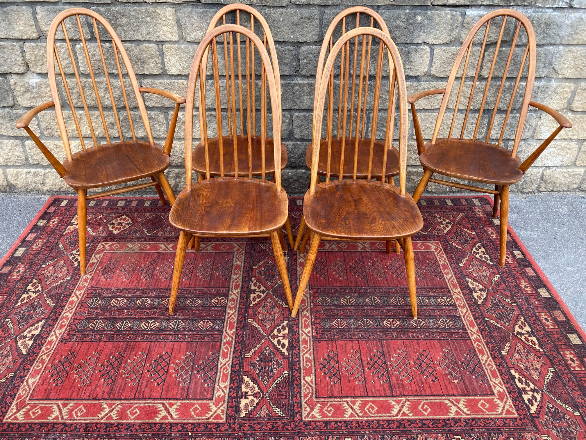 A set of six mid-20th Century Ercol high back dining chairs, two with arms, bearing