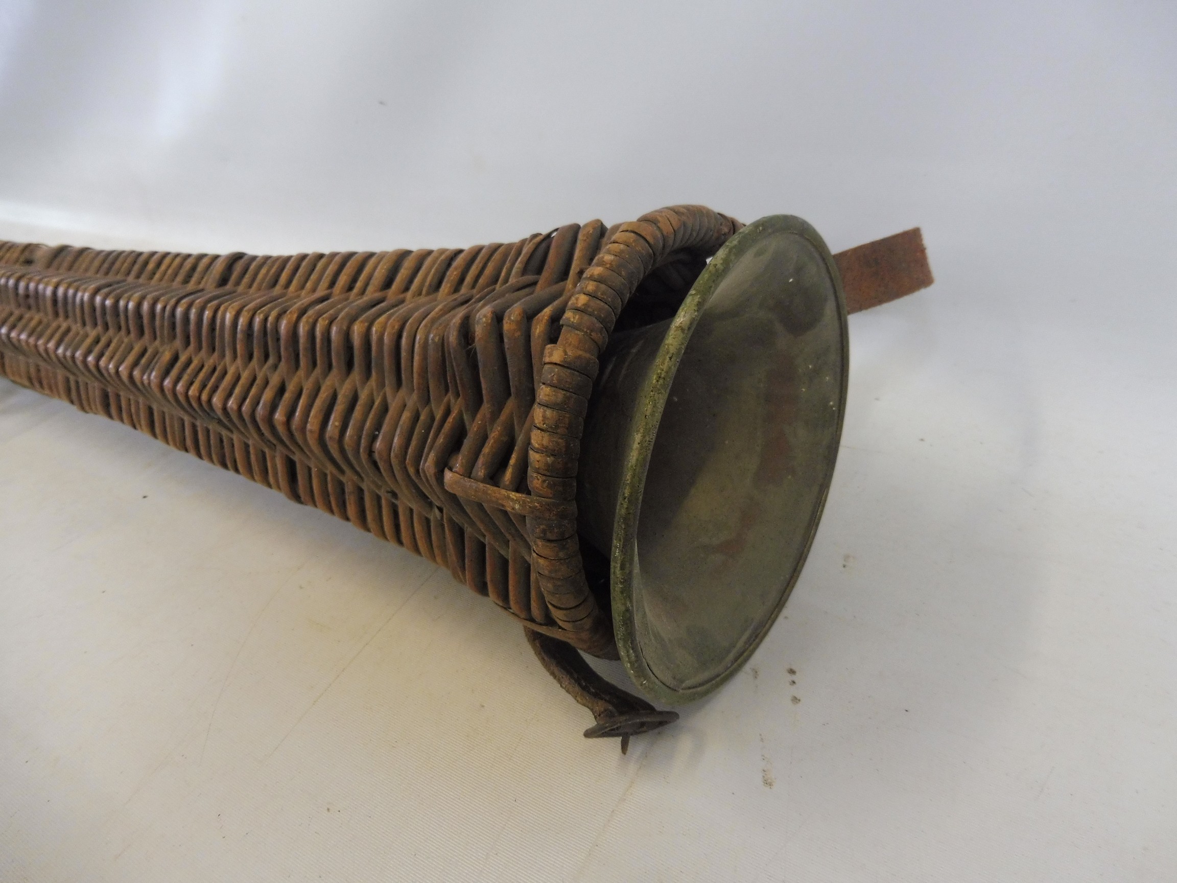 A 19th Century coaching horn, probably Irish, in a wicker case, the horn 37 1/2" long; Provenance