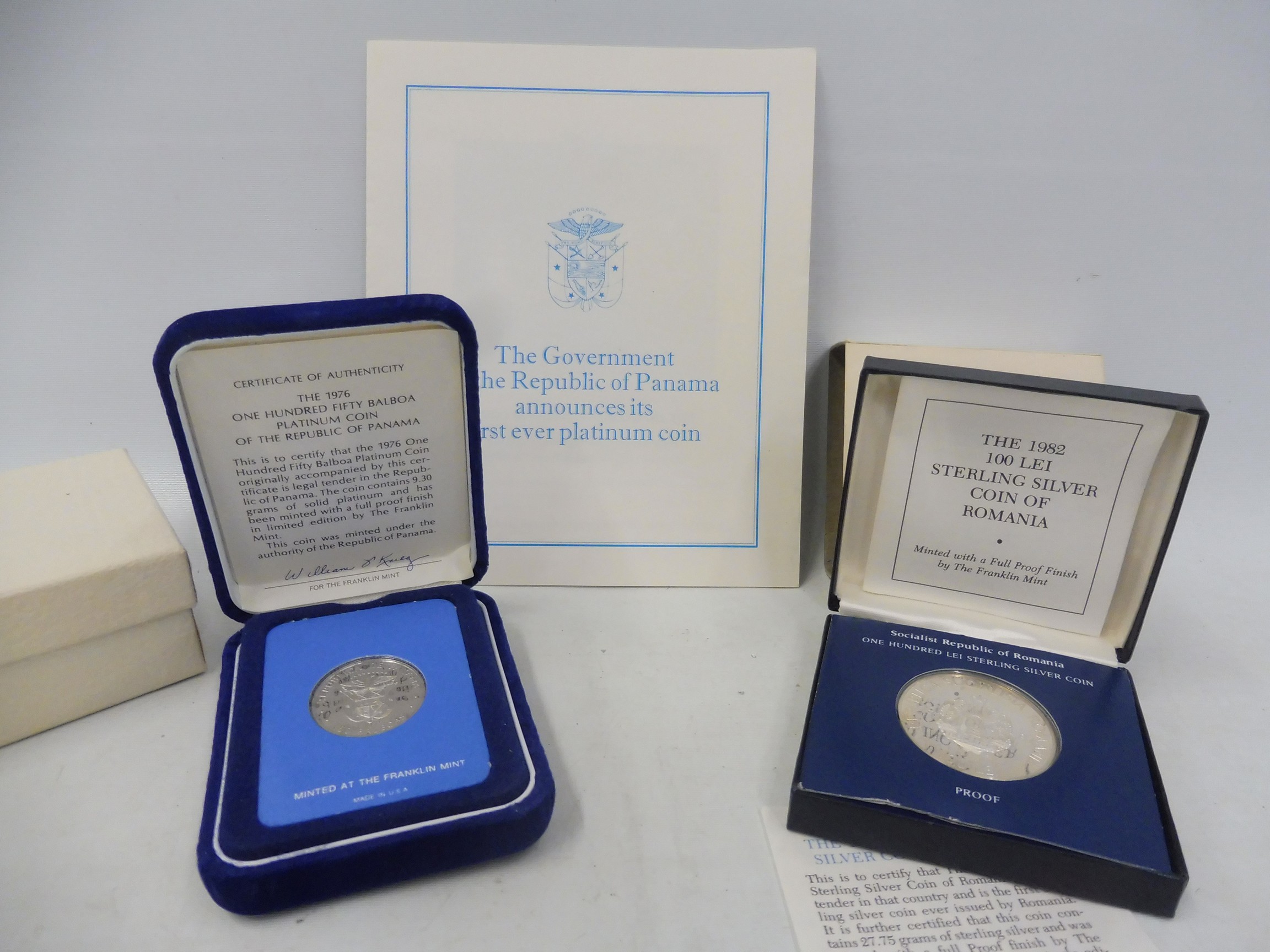 A cased 1976 150 balboa platinum coin of Panama, with certificate and booklet plus a 1982 100 lei