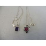 A ruby and silver heart shaped pendant on a silver chain and an amethyst and silver pendant on