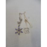 A tanzanite and silver snowflake-shaped pendant on a silver chain and a diamond inset butterfly-