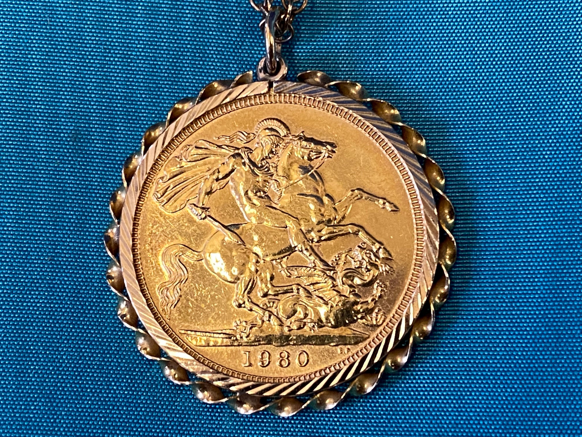 A 1980 gold sovereign in a gold mount hanging on a gold chain, overall weight approx. 13g.