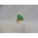 A gold ring set with jade, approx. 5.1g, size L/M.